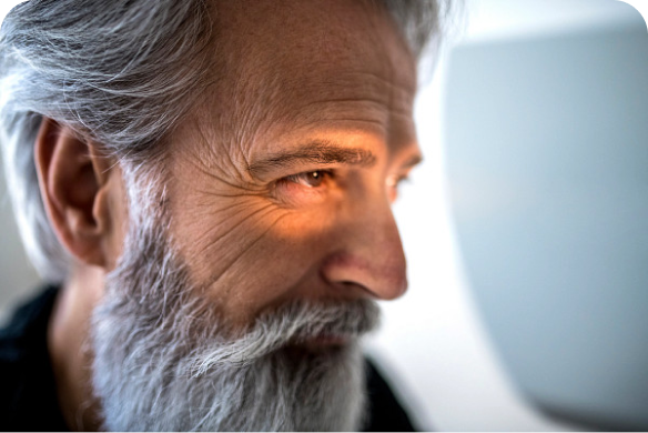 Man smiling into eye examination device
