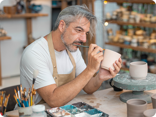a man painting a mug
