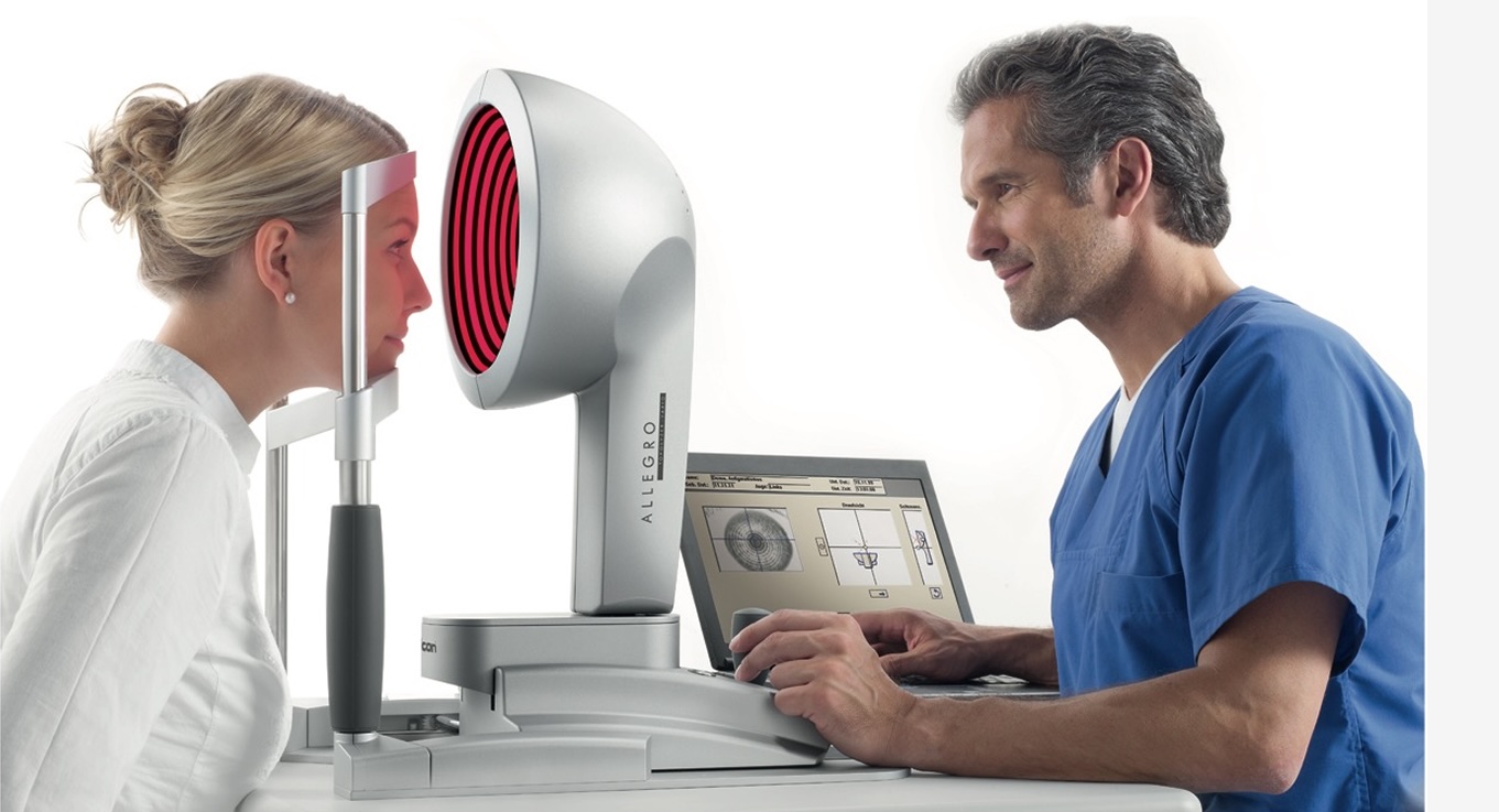 An ophthalmologist conducting an eye examination on a patient using the WaveLight® Topolyzer VARIO™ device, demonstrating its use in practice.