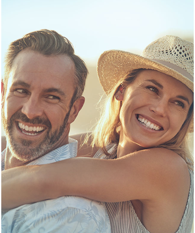 Couple embracing in sunlight while smiling