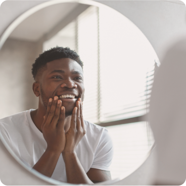 A man smiling looking in the mirror.