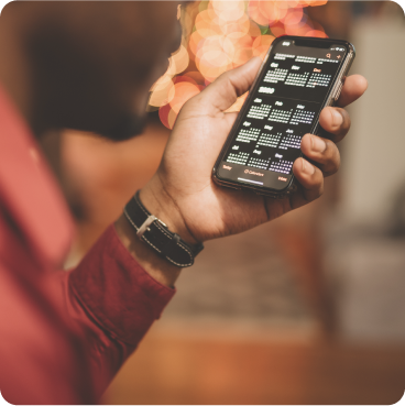 hand holding a mobile phone with a calendar showing on the screen