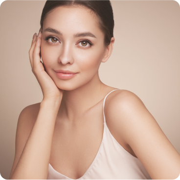 woman with beautiful brown eyes and dark pulled up hair wearing light colored tank top