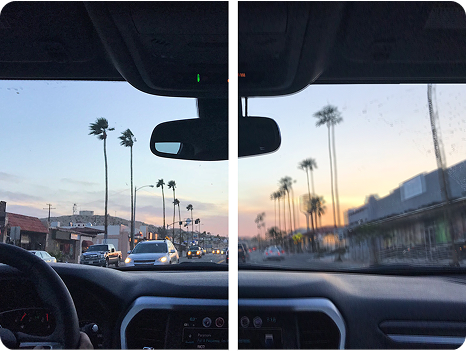 A split-view image illustrating a vision correction comparison showing a driver's perspective of a city street lined with palm trees during sunset. The left side appears slightly blurry or hazy, while the right side is clear and sharp.