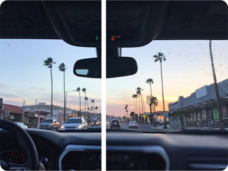 A split-view image illustrating a vision correction comparison showing a driver's perspective of a city street lined with palm trees during sunset. The left side appears slightly blurry or hazy, while the right side is clear and sharp.